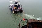 Mit geschickter Fahrweise bugsiert der Bootsführer die Förderbrücke über den See (Foto: Uwe Bollmer)