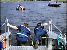 THW-Helfer ziehen die gerettete Person an Bord des MzAB