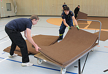 Helfer beim Verlegen der Teppichmatten in der Turnhalle des BSZ (Foto: Susan Schmidt)